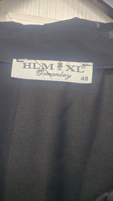 3 duymə koynək: Qara rəngdə, uzunqol, asimmetrik dizaynlı köynək. Bir tərəfi iri — 3