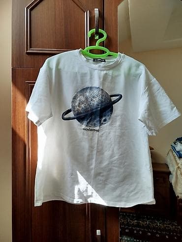 Ağ rəngli qısaqoll T‑şort. Ön hissədə üzüklü planet qrafikası və