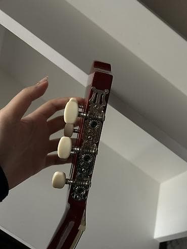 Гитары: Açıq ağac rəngində klassik dizaynlı akustik gitara. Alət altı simlidir — 4