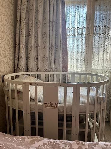 Uşaq beşiyi – ağ rəngdə, oval/dairəvi dizayn. Taxta konstruksiya