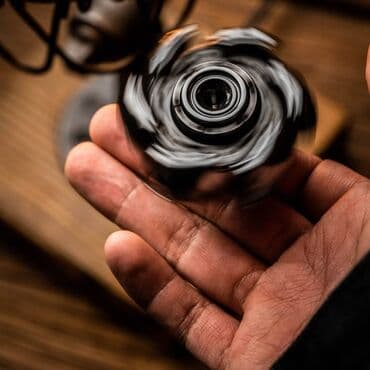 Fırlanan qara rəngli fidget spineri, əldə tutmaq üçün rahat dizayna