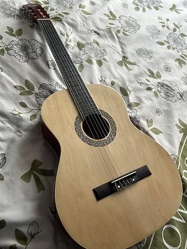 Гитары: Açıq ağac rəngində klassik dizaynlı akustik gitara. Alət altı simlidir — 2