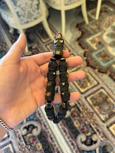 yuxuda sac rezini gormək: Qədimi üslubda, qara rəngdə, kəllə formalı bəzədilmiş təsbeh. Əl — 2