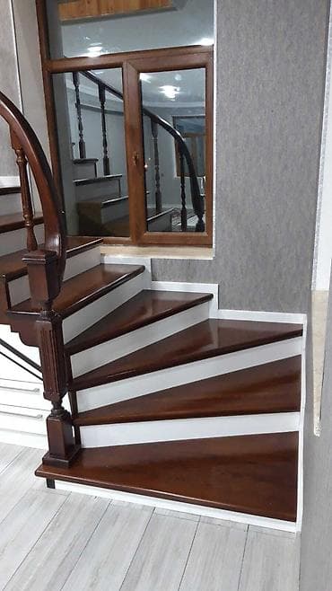 Qəhvəyi rəngli, ağ pilləkənləri olan spiral pilləkən. Bu dizayn evdə