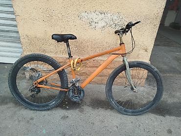 Portağal rəngli, qalın təkərli, çoxsürətli velosiped. Metal çərçivəyə