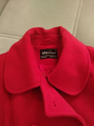 palto qadın üçün: Qırmızı rəngdə qadın paltosu, klassik dizayna malikdir. Yanlarında — 2