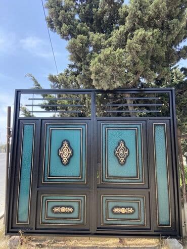 demir qapi bezekleri: Qara rəngdə, bürünc elementlərlə bəzədilmiş metal qapı. Qapının — 3