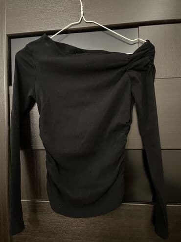 Zara, asimetrik çiyinli qara kofta Çiyni ve yanları büzgülü modeldir