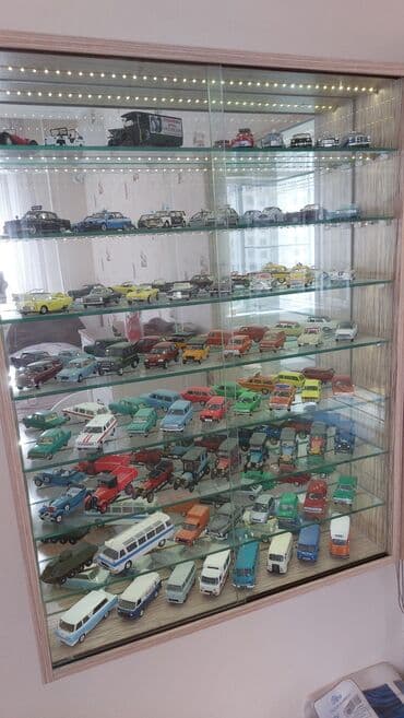 Şüşə qapıları olan vitrin, model avtomobillər kolleksiyasını səliqəli