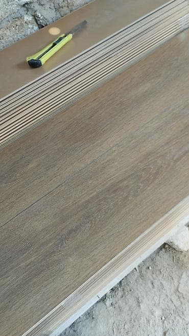 dekor agaclar: Laminate döşəmə taxtaları – ağac naxışlı, isti qəhvəyi ton. Məhsul — 1