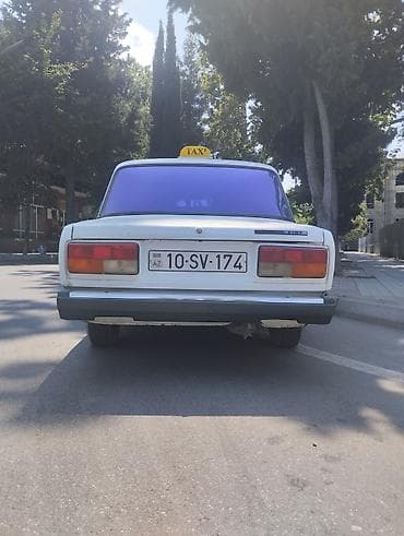 sam diskler: VAZ 2107, ağ rəng, sedan kuzov. Arxa şüşədə bənövşəyi rəngli plyonka — 2