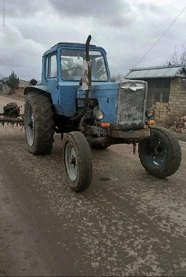 sepli traktor: Sükanlı kabinli mavi traktor, arxasında kotan/oydaşı (tillər) qoşqusu — 1