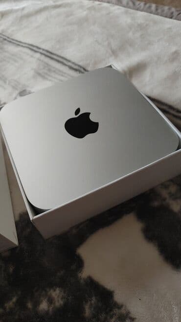 Masaüstü kompüterlər və iş stansiyaları: Apple Mac Mini – gümüşü rəngdə, yığcam və masaüstü kompüter. Evdə — 1