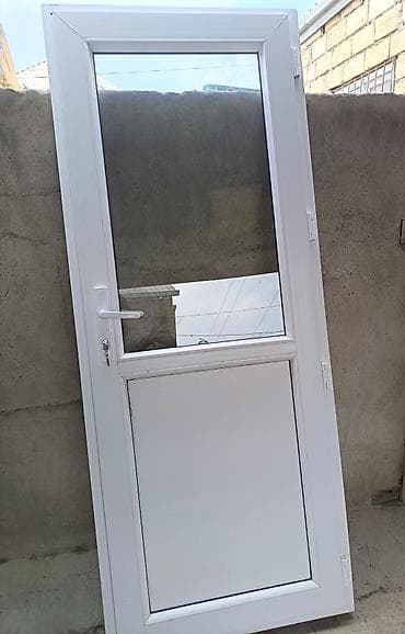 Ağ rəngli PVC qapı. Qapının yuxarı hissəsi şüşəli, aşağı hissəsi isə
