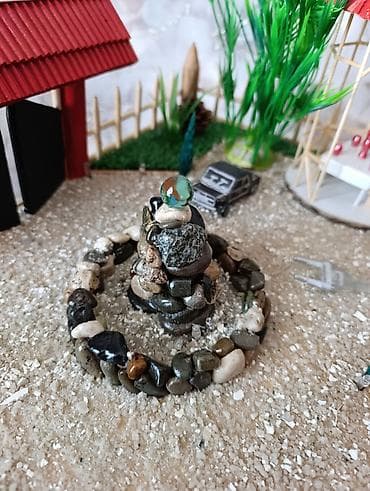 flo memar ecemi: Miniatür ev modeli, qırmızı damı və ətrafında hasarlı yaşıllığı ilə — 9