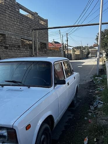 raf masin: VAZ 2107, ağ rəng, sedan kuzov. 4 qapı, 5 yerlik salon. Qara radiator — 4
