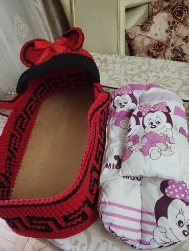 Əl işi olan, toxunma, qırmızı və qara rəngli uşaq beşiyi. Beşikdə