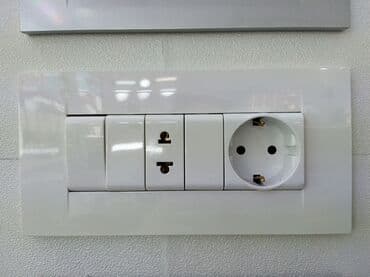 roza: Ağ rəngli, geniş çərçivəli elektrik rozetka və açar paneli. Paneldə — 1