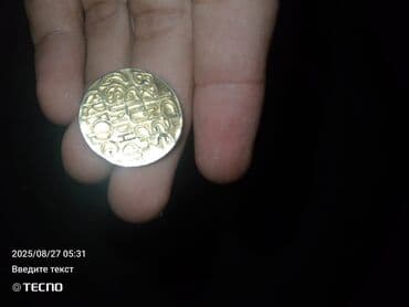 Dekorativ sikkə, üzərində mürəkkəb naxışlar və simvollar olan metal