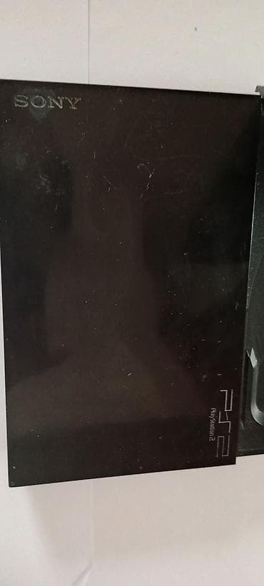 playstation 2 oyun: Sony PlayStation 2 konsolu. Qara rəngdə olan bu konsol, disk oxuyucuya — 4
