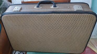 Naxışlı səthə malik, qəhvəyi rəngli vintaq çamadan. Çamadanın qara