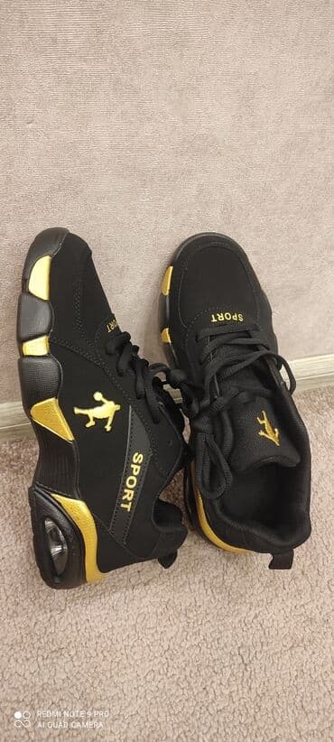 çəkmə kişi: Qara-qızılı idman ayaqqabısı - Dizayn: Qara üstlük, qızılı detallarla — 1