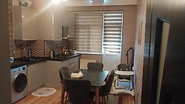 şeki: Mənzilin təsviri: - Geniş və işıqlı zal: divardan asılan televizor — 2