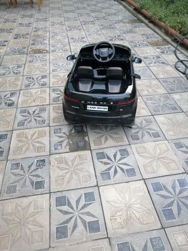 ucuz uşaq maşınları: Uşaqlar üçün nəzərdə tutulmuş qara rəngli elektrikli maşın. Bu model — 2