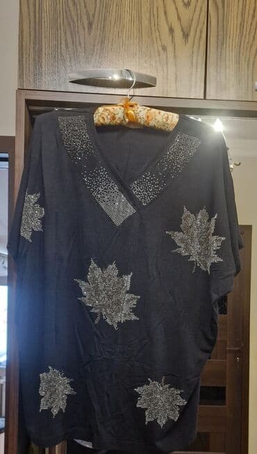 Qara rəngdə, V-yaxa və yarpaq naxışlı qadın bluzası. Bluzanın ön