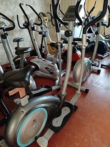 Gümüşü rəngdə, idman məşqləri üçün nəzərdə tutulmuş elliptik trenajor