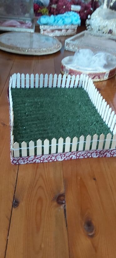 Novruz xoncasi. Ot örtüyü və ağ çəpər detalları ilə bəzədilmiş