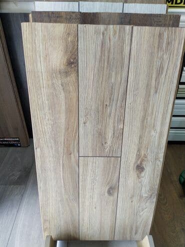 Açıq rəngli, taxta görünüşlü laminat döşəmə panelləri. Bu panellər