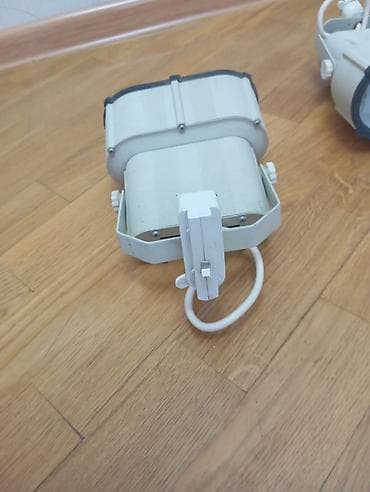 İki ədəd ağ rəngli proyektor lampası. Bu lampalar müxtəlif məkanlarda