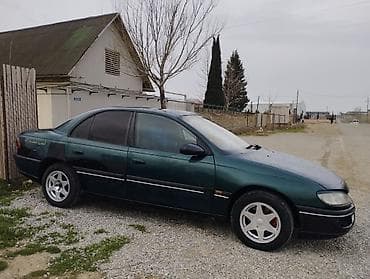 Opel: Opel sedan – yaşıl rəng, 4 qapılı, arxa çəkiliş emblemli model. Xarici — 3