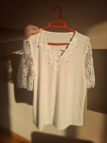 Ağ rəngli qadın bluzu. Model sadə və zərif üslubda hazırlanıb. Qolları