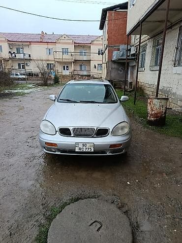 8 km teker bazarı: Gümüşü rəngli Daewoo Espero sedan. Avtomobilin dörd qapısı və günəş — 1