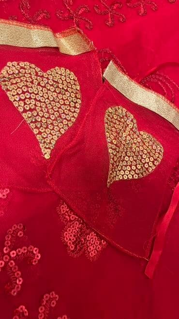 Qırmızı rəngli, ürək formalı parlaq elementlərlə bəzədilmiş zərif