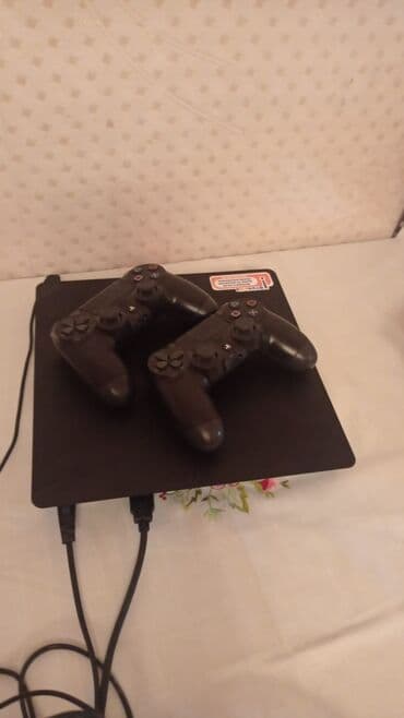 Sony PlayStation 4 Slim konsolu iki qara rəngli DualShock 4 pultu ilə lalafo.az -da Sony PlayStation 4 Slim konsolu iki qara rəngli DualShock 4 pultu ilə