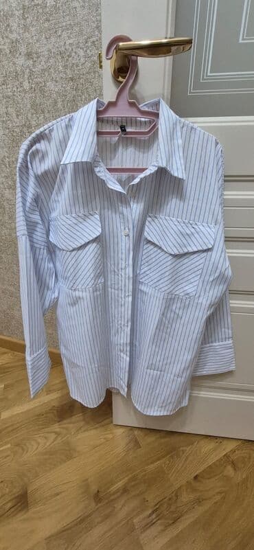 Ağ fonda nazik mavi zolaqlı qadın köynəyi. Klassik yaxalı, düyməli ön lalafo.az -da Ağ fonda nazik mavi zolaqlı qadın köynəyi. Klassik yaxalı, düyməli ön