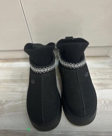 UGG brendinin qara rəngli uniseks qış ayaqqabısı. Model, ayaq biləyinə lalafo.az -da UGG brendinin qara rəngli uniseks qış ayaqqabısı. Model, ayaq biləyinə