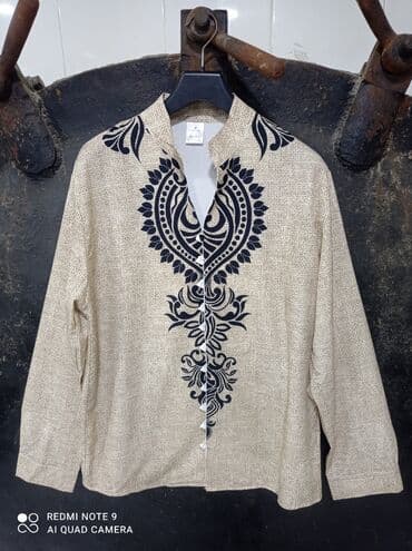 Bej rəngli, uzunqol, düyməli köynək. Ön hissədə qara rəngdə böyük lalafo.az -da Bej rəngli, uzunqol, düyməli köynək. Ön hissədə qara rəngdə böyük