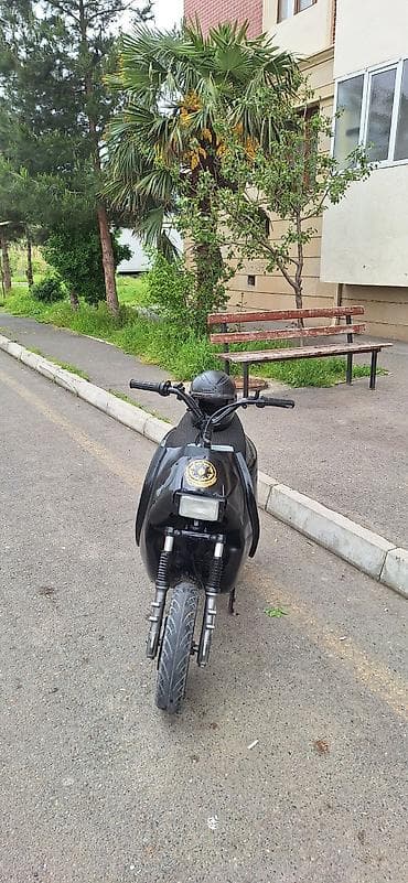 Qara rəngli şəhər skuteridir. Kompakt kuzov, enli ön təkər və ikili ön lalafo.az -da Qara rəngli şəhər skuteridir. Kompakt kuzov, enli ön təkər və ikili ön